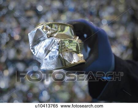 Stock Photography - Worker Holding Crushed Tin Can. Fotosearch