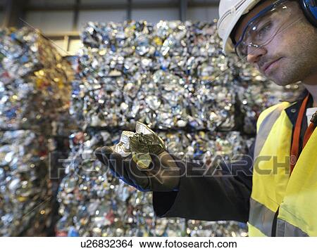 Picture - Worker In Recycle Plant Holding Can. Fotosearch