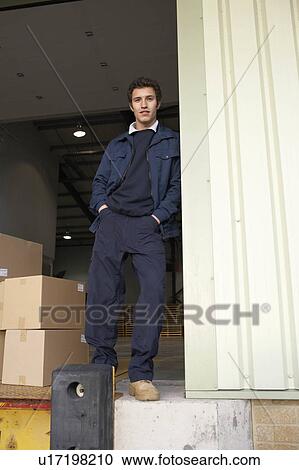 Stock Image - Worker in warehouse doorway. Fotosearch