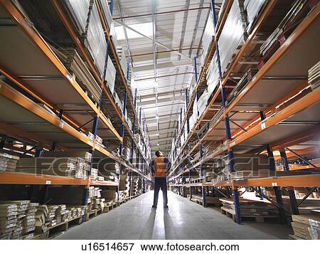 Stock Photo - Worker Inspecting Goods In Warehouse. Fotosearch