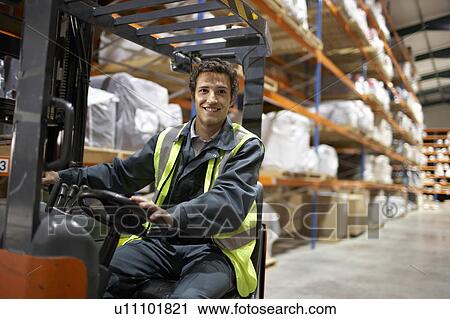 Stock Image - Worker on forklift, smiling to camera. Fotosearch