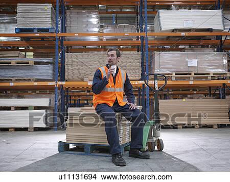 Worker Taking A Break In Warehouse View Large Photo Image Picture - Worker Taking A Break In Warehouse. Fotosearch