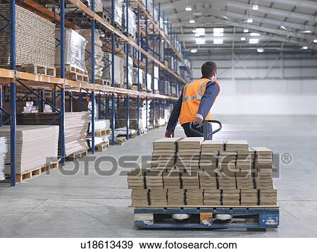 Worker Transporting Load In Warehouse View Large Photo Image Stock Photo - Worker Transporting Load In Warehouse. Fotosearch
