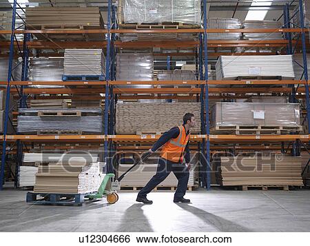 Worker Transporting Product In Warehouse View Large Photo Image Stock Photograph - Worker Transporting Product In Warehouse. Fotosearch