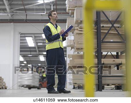 Stock Photo - Worker With Clipboard In Warehouse. Fotosearch