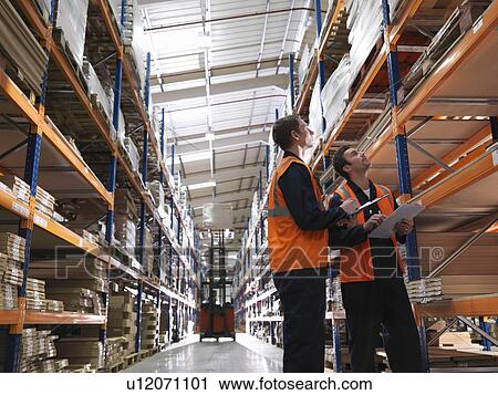 Stock Image - Workers And Forklift In Warehouse. Fotosearch