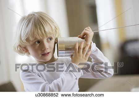 young boy playing with can phone View Large Photo Image Stock Image - young boy playing with can phone. Fotosearch