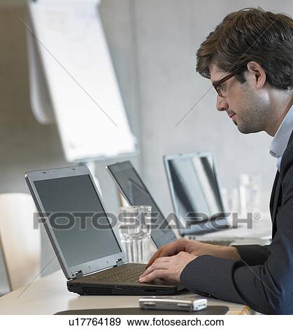 Young businessman using laptop View Large Photo Image Stock Photo - Young businessman using laptop. Fotosearch