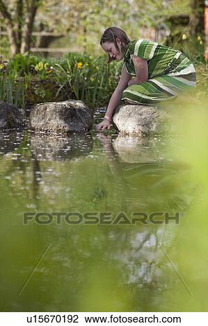 Stock Image - young girl at pond. Fotosearch
