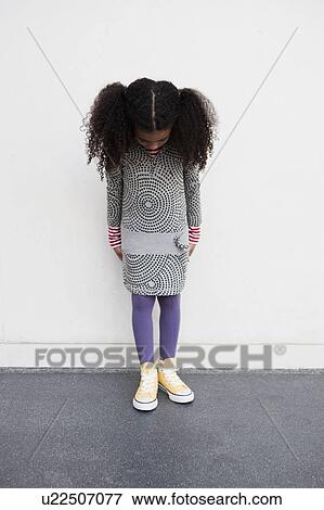 Stock Photo - young girl looking down her legs. Fotosearch