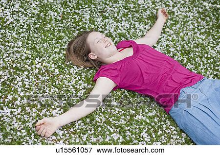 young girl lying in grass View Large Photo Image Stock Photo - young girl lying in grass. Fotosearch
