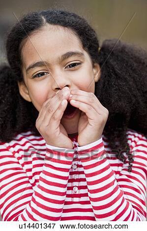 Stock Photo - young girl with hands folded around lips. Fotosearch