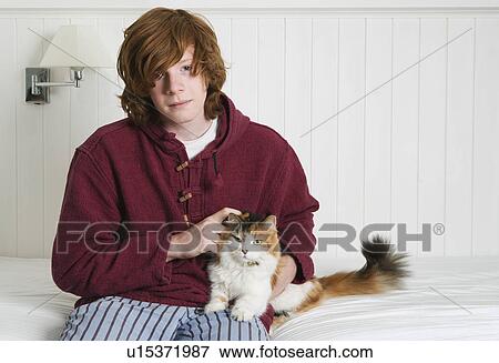 Stock Photo - Young man stroking cat. Fotosearch