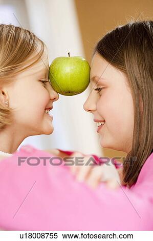 young sisters with apple View Large Photo Image Stock Photography - young sisters with apple. Fotosearch