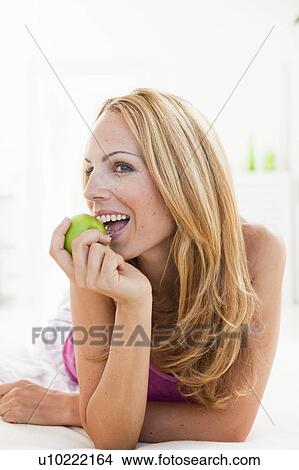 Picture - young woman enjoying apple. Fotosearch