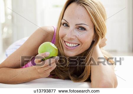 young woman enjoying apple View Large Photo Image Stock Photo - young woman enjoying apple. Fotosearch