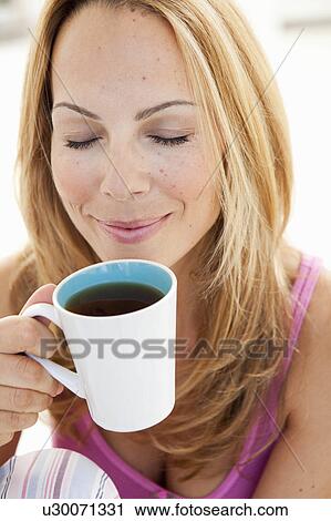 young woman enjoying cup of tea View Large Photo Image Stock Image - young woman enjoying cup of tea. Fotosearch