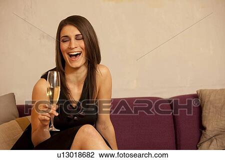 Young woman holding glass of champagne View Large Photo Image Stock Image - Young woman holding glass of champagne. Fotosearch