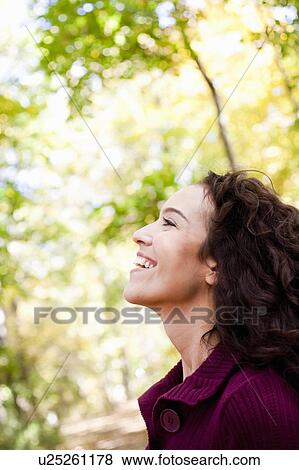 Stock Photo - young woman in the woods smiing. Fotosearch