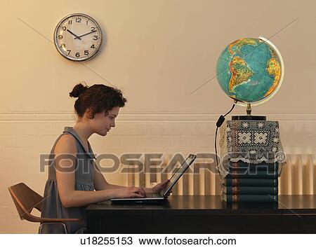 Stock Image - Young woman on laptop. Fotosearch