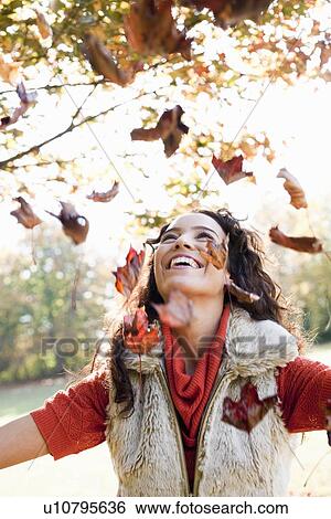 young woman playing with leaves View Large Photo Image Stock Photograph - young woman playing with leaves. Fotosearch