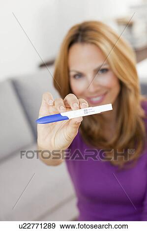 Stock Photo - young woman showing pregnancy test. Fotosearch