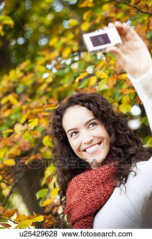 Stock Photo - young woman taking self-portrait. Fotosearch