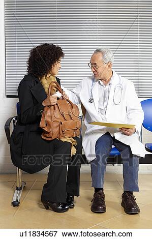 Young woman talking to doctor View Large Photo Image Stock Photo - Young woman talking to doctor. Fotosearch
