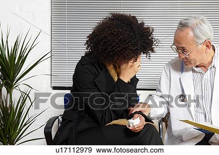 Stock Photo - Young woman talking to doctor. Fotosearch