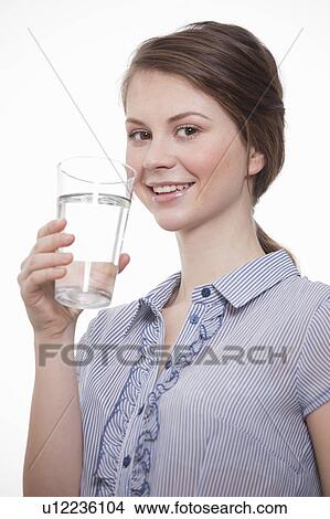 Young women holding a glass of water View Large Photo Image Picture - Young women holding a glass of water. Fotosearch