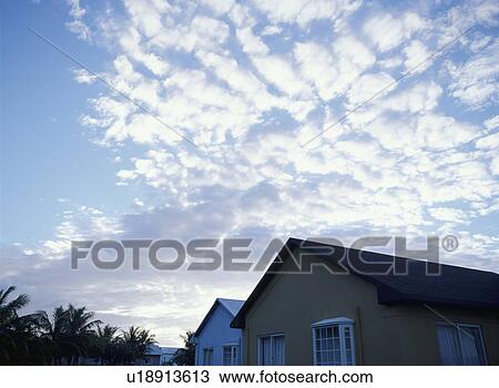Stock Image - Blue sky, clouds and houses. Fotosearch