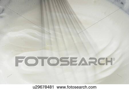 Stock Image - Bowl of whipped cream, close up, blurred motion. Fotosearch