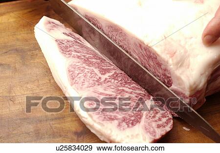 Stock Photo - Chef cutting meat, close up. Fotosearch