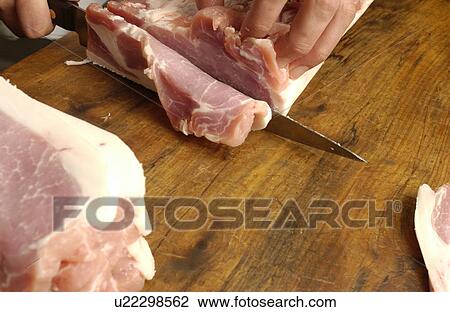 Stock Image - Chef cutting meat. Fotosearch