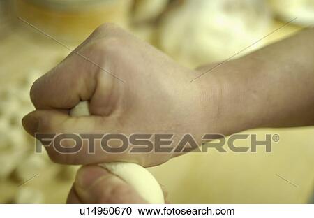 Stock Image - Chef holding dough, making dim sum, close up. Fotosearch