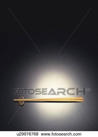 Stock Photo - Chopsticks on holder, black background. Fotosearch