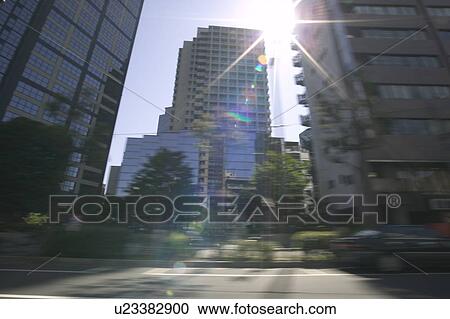 Stock Image - Cityscape, blurred motion, lens flare, Tokyo prefecture, Japan. Fotosearch