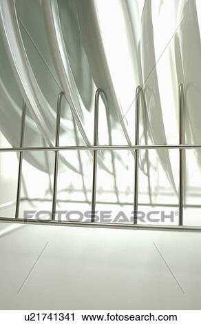 Stock Image - Clean plates on dish rack, close up, white background. Fotosearch