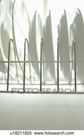 Stock Photography - Clean plates on dish rack, white background. Fotosearch