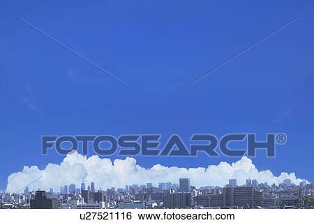 Stock Photograph - Cumulonimbus clouds over city, copy space. Fotosearch