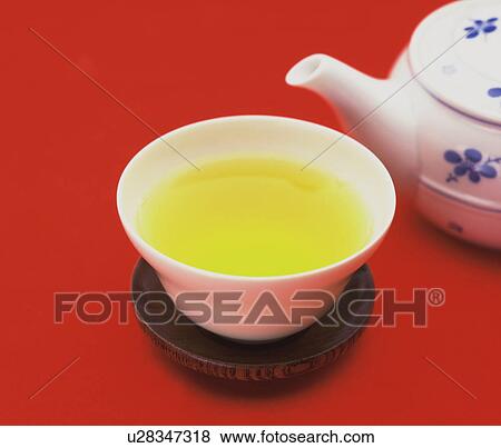 Stock Photo - Cup of green tea, red background. Fotosearch