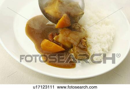 Curry being poured on plate of rice, white background View Large Photo Image Stock Image - Curry being poured on plate of rice, white background. Fotosearch