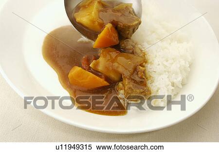 Curry being poured on plate of rice, white background View Large Photo Image Stock Photography - Curry being poured on plate of rice, white background. Fotosearch