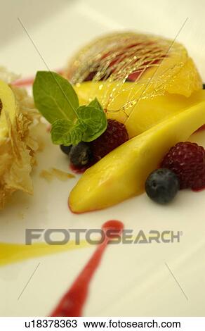 Stock Image - Cut fruits on plate, close up. Fotosearch