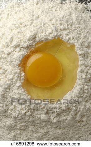 Stock Photo - Egg on flour, close up. Fotosearch