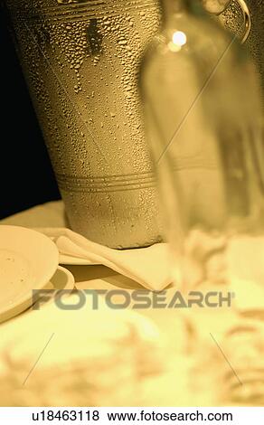 Stock Photo - Empty wine bottle and ice bucket, close up. Fotosearch
