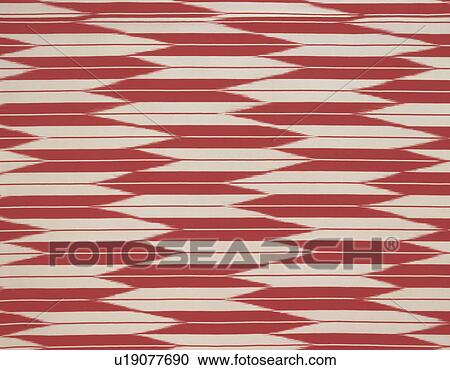 Stock Image - Fabric patterned with red and white arrows, close up, full frame. Fotosearch