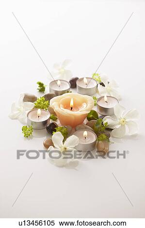 Stock Photography - Flowers and burning candles, white background. Fotosearch