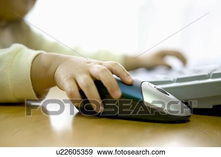 Girl using computer, holding computer mouse View Large Photo Image Stock Photo - Girl using computer, holding computer mouse. Fotosearch