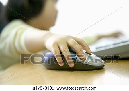 Stock Photography - Girl using computer, holding computer mouse, differential focus. Fotosearch